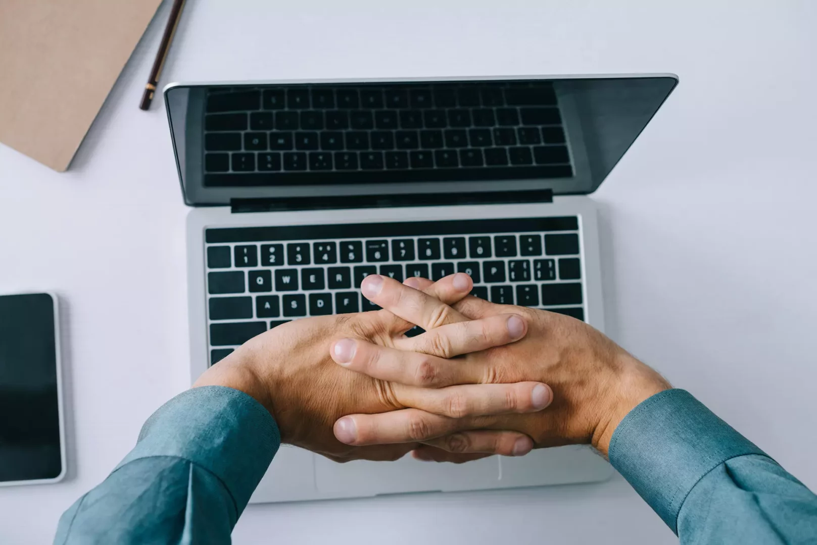 Man stretching fingers above laptop keyboard, preparing for development of app