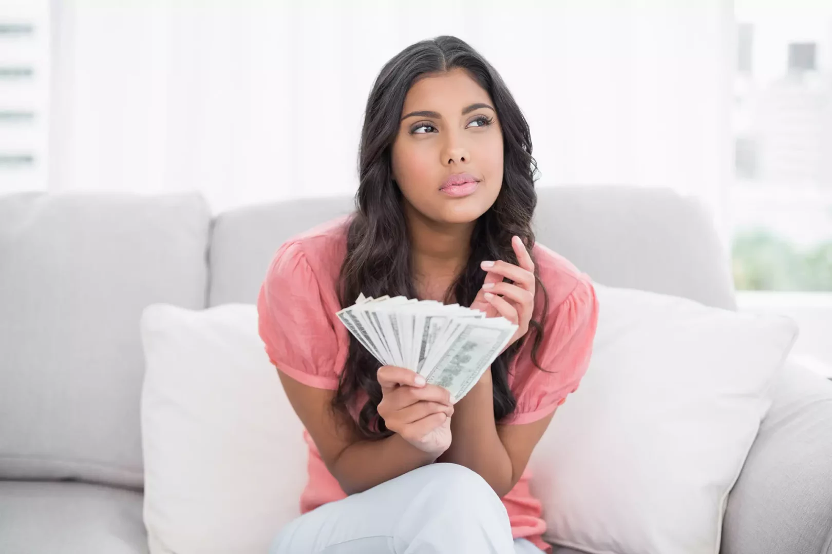 Young woman thinking how much it costs to develop a native mobile app